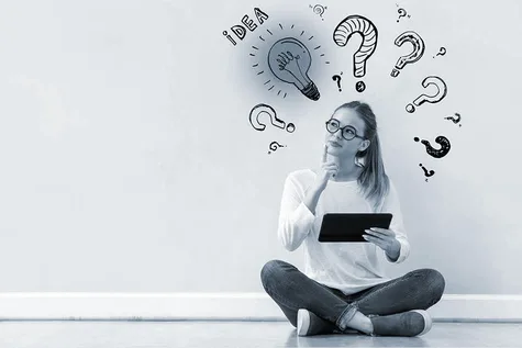 Eine Frage mit einem Tablet, die nachdenklich aussieht. Hinter ihr an der Wand stehen Fragezeichen