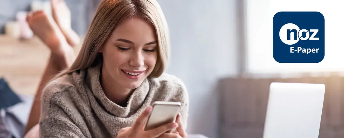 Frau schaut aufs Smartphone mit E-Paper-App