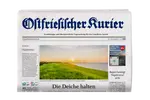 Titelseite einer Regionalzeitung mit einem Deich bei Sonnenuntergang, Windrädern am Meer und der Schlagzeile 'Die Deiche halten'.